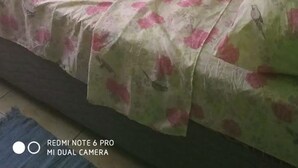 A room with green walls, a bed with a floral bedspread, and an air conditioning unit mounted on the wall. - Village No Thrill 2 Bed (Gros Islet)