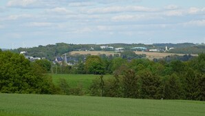 A rural landscape with wind turbines, a church, and residential buildings. - Apartment house Monika (Bergenhausen)