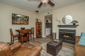 Ein Wohnzimmer mit Kamin, Essbereich und einer Küche im Hintergrund.