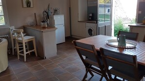 Una cocina compacta con comedor, lavadora y refrigerador.