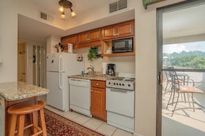 Una cocina equipada con refrigerador, lavavajillas, microondas, estufa y un comedor con mesa y sillas.