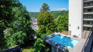 Un hôtel doté d’une piscine, entouré d’arbres et offrant une vue sur la ville.