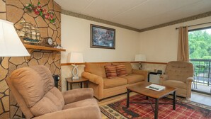 Een woonkamer met een bank, fauteuil, salontafel en een decoratieve klok.