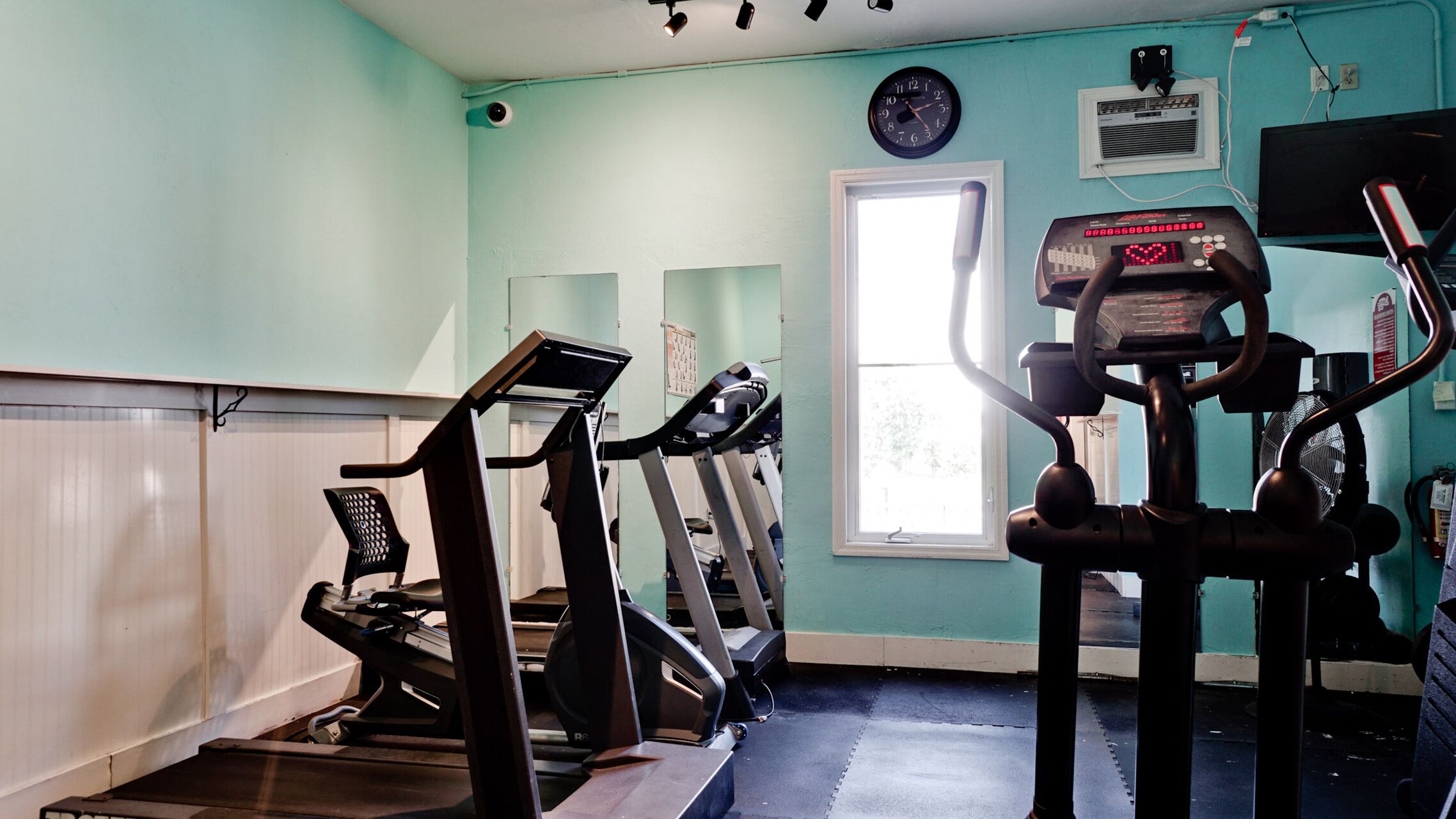 A gym with treadmills, a stationary bike, and a rowing machine.