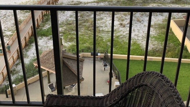 Ein Balkon mit Blick auf Strand und Meer.