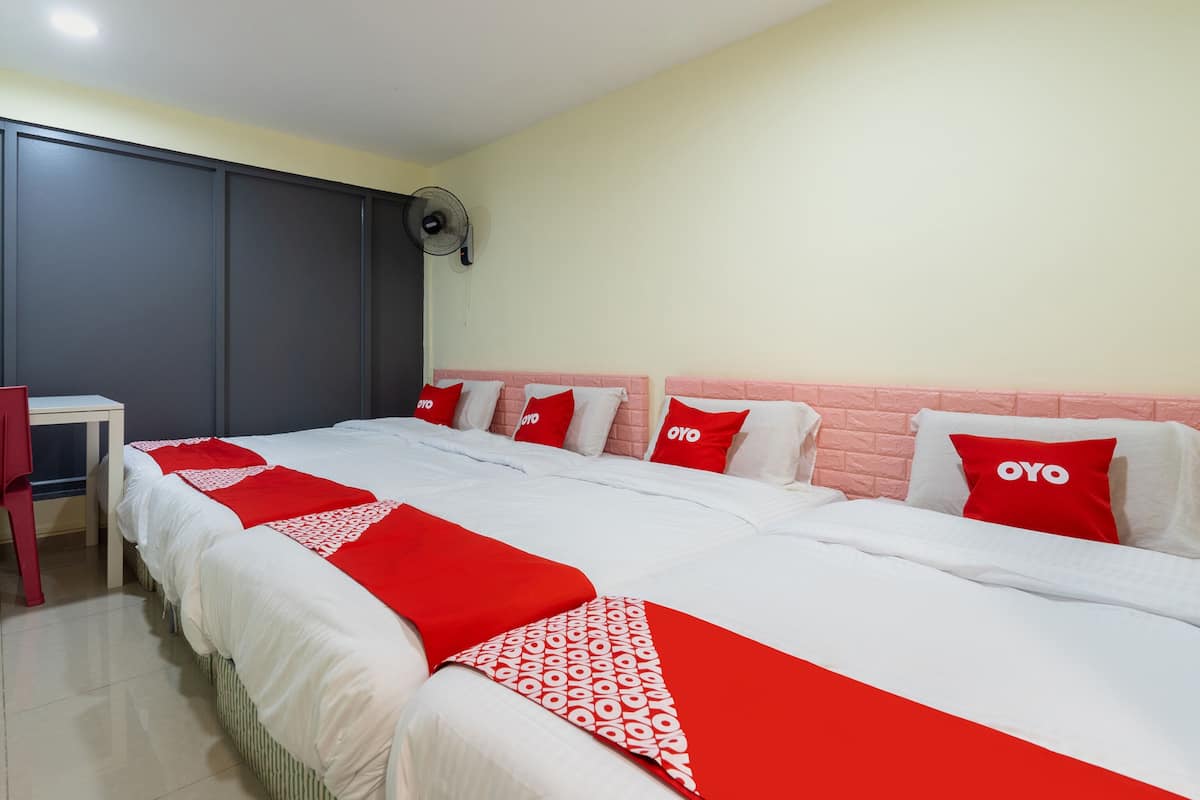 A hotel room with a large bed, a desk, and a chair.