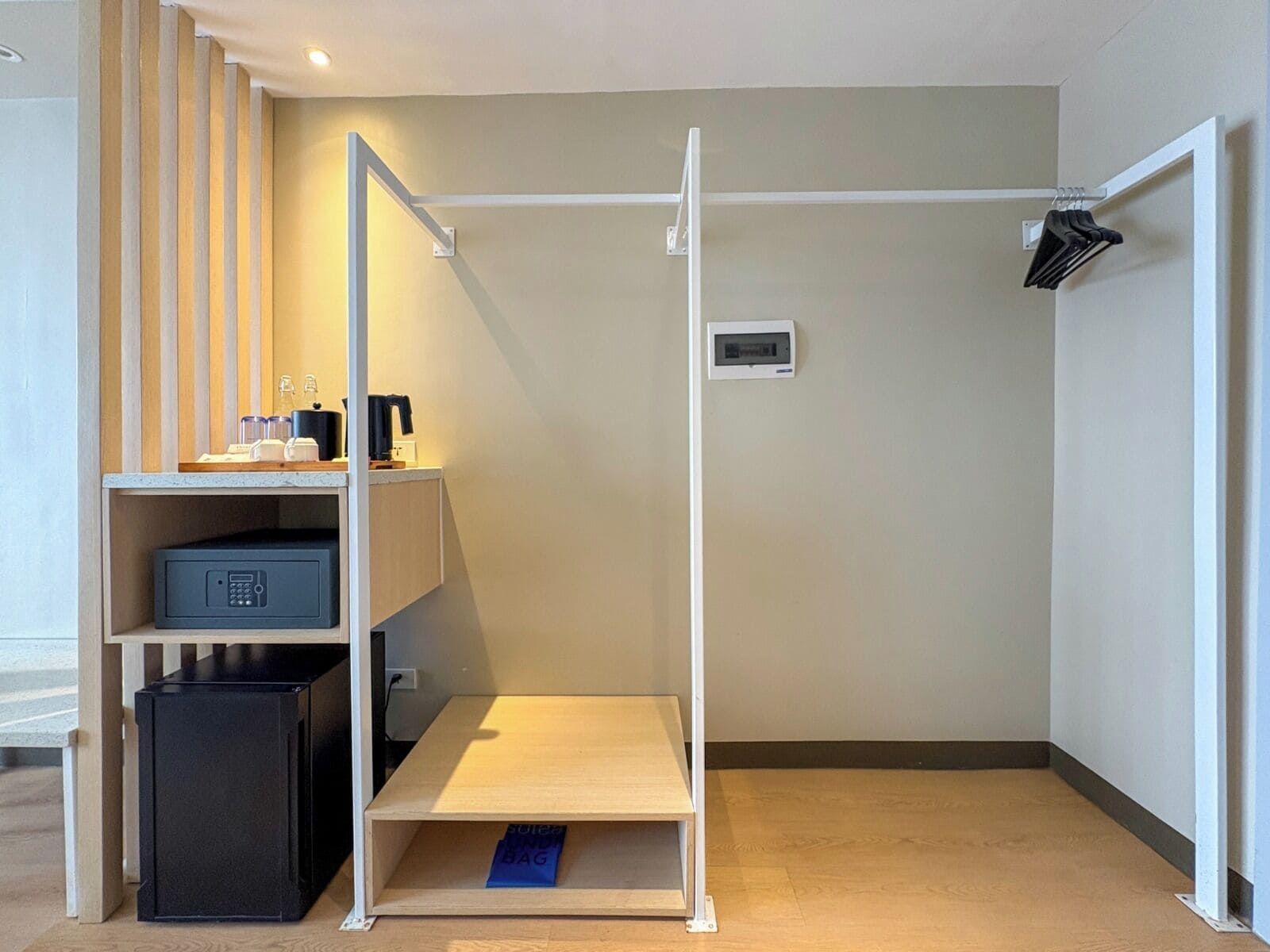 Ein kompaktes Zimmer mit Schreibtisch, Ablagefläche, Mülleimer, ausziehbarer Ablage und Wandheizung.