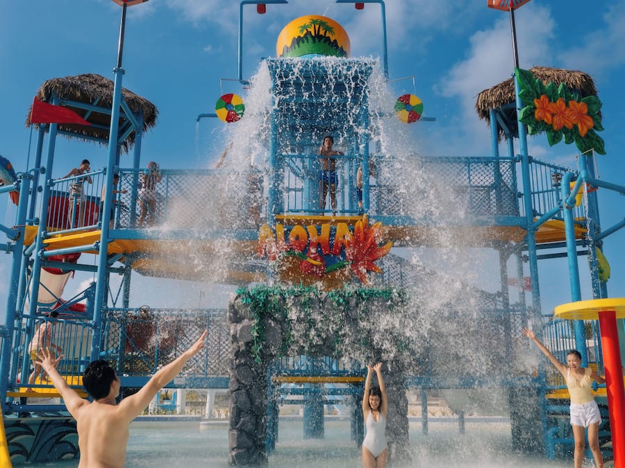 A water park with a large water slide and multiple play structures.