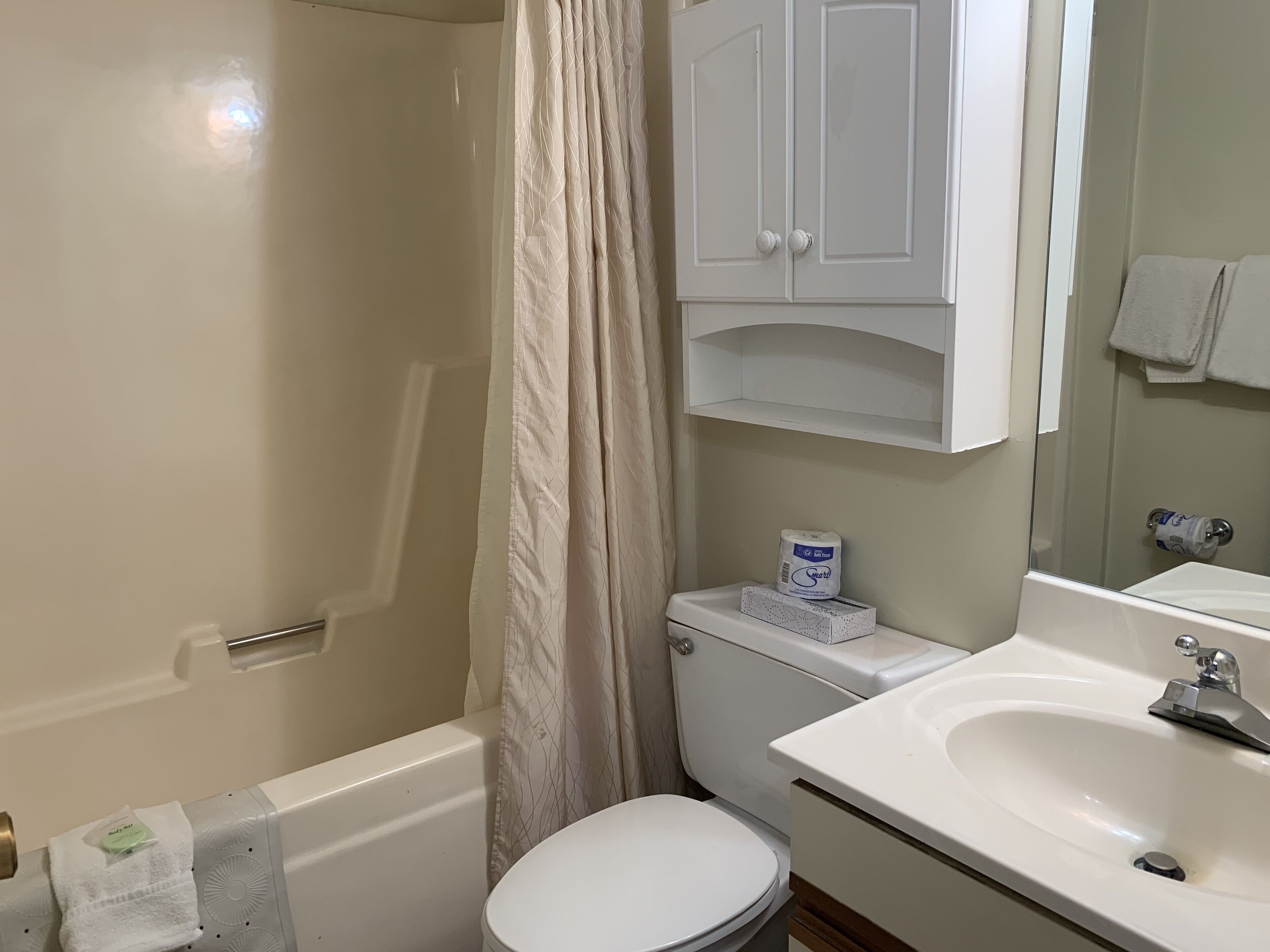 A bathroom with a bathtub, toilet, and sink.
