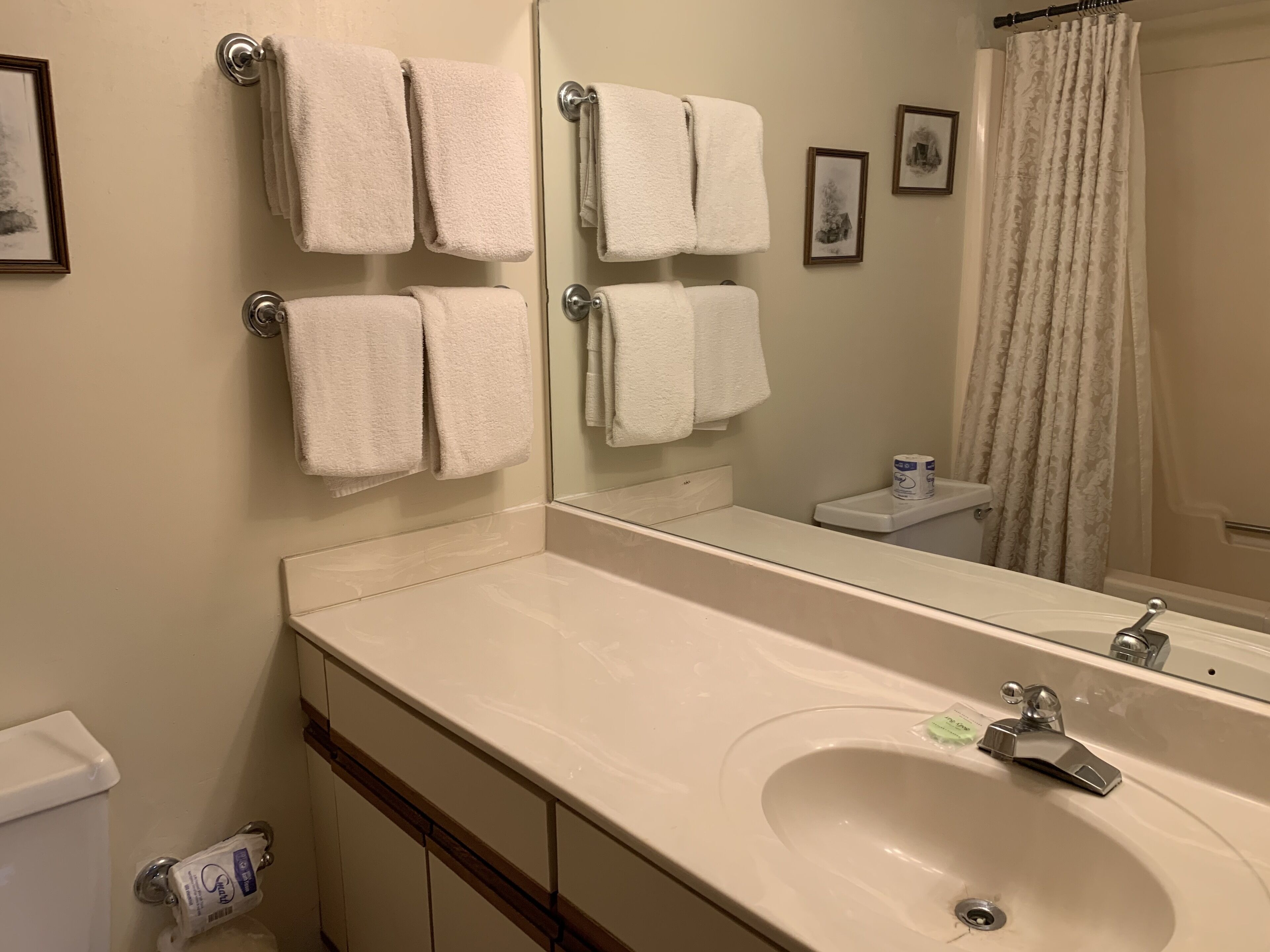 Une salle de bain avec un lavabo, un miroir et un porte-serviettes.