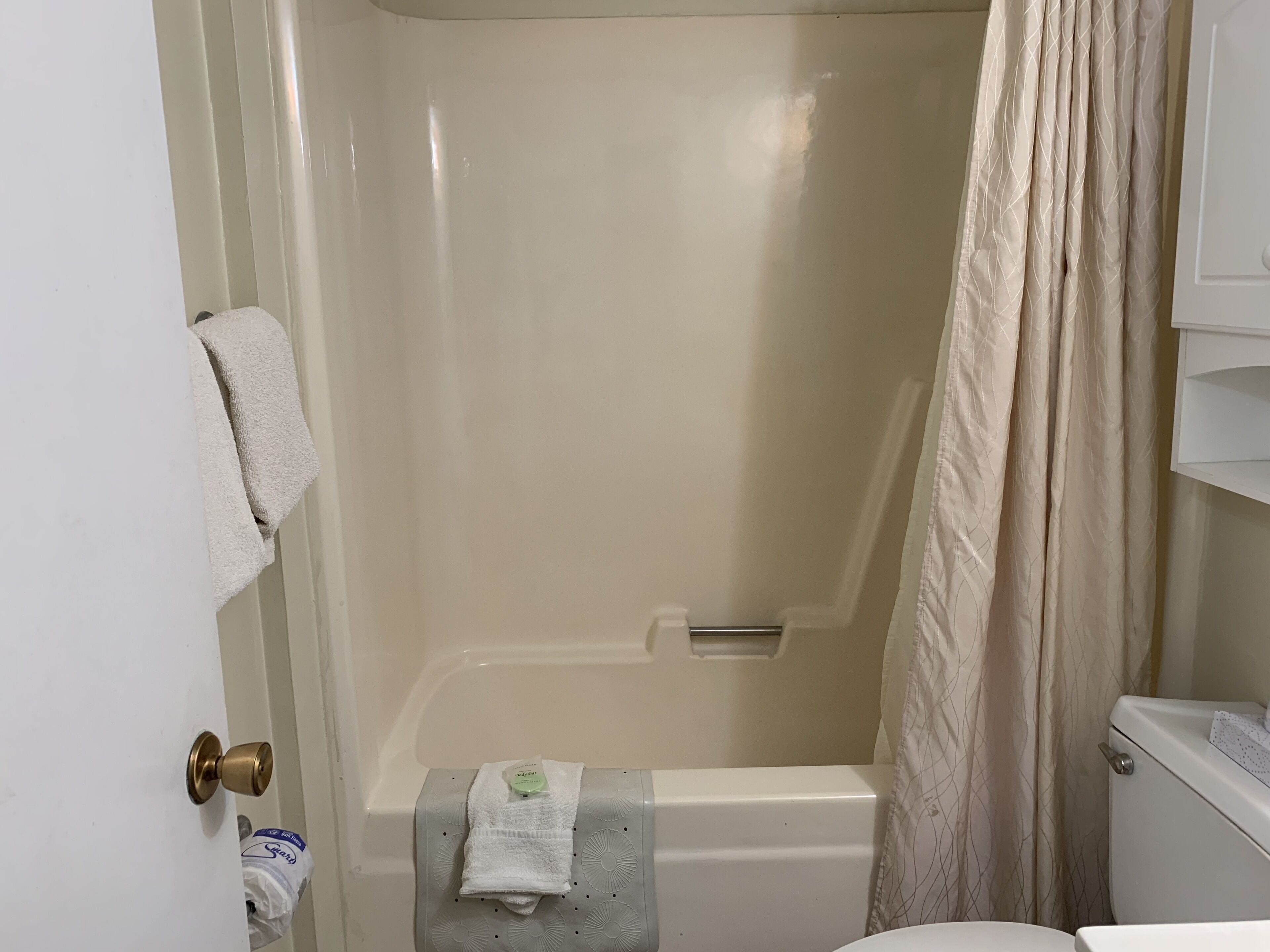 Une salle de bain avec une baignoire, des toilettes et un porte-serviettes.