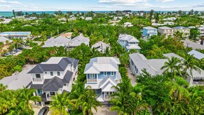 A coastal residential area with houses, palm trees, and a beach.