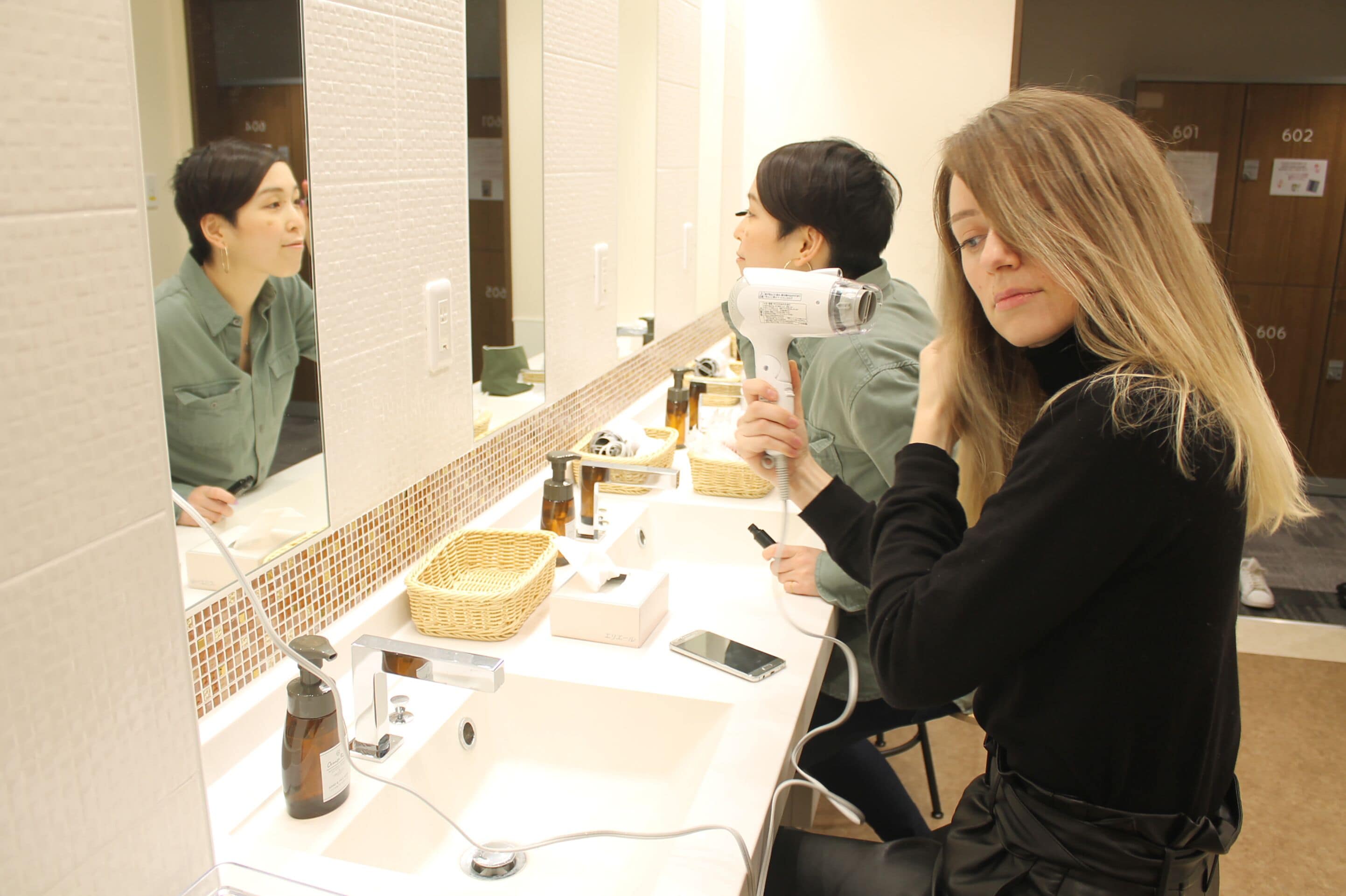 A bathroom with a sink, mirror, and various toiletries.