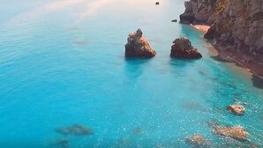 A coastal scene with clear turquoise water, rocky formations, and a sandy beach. - Apartment in residence in Mongiove a stone's throw from the sea (Mongiove)