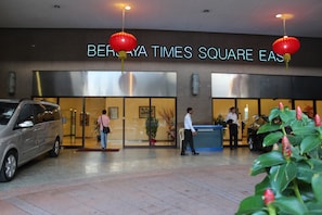 Een hotelentree met een bord waarop 'BERMUDA TIMES SQUARE EAST' staat.
