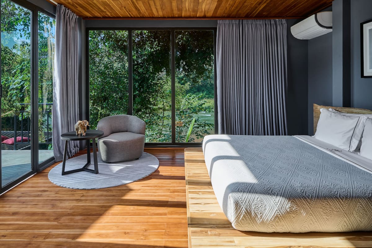 Une chambre moderne avec un grand lit, une petite table ronde et une chaise.