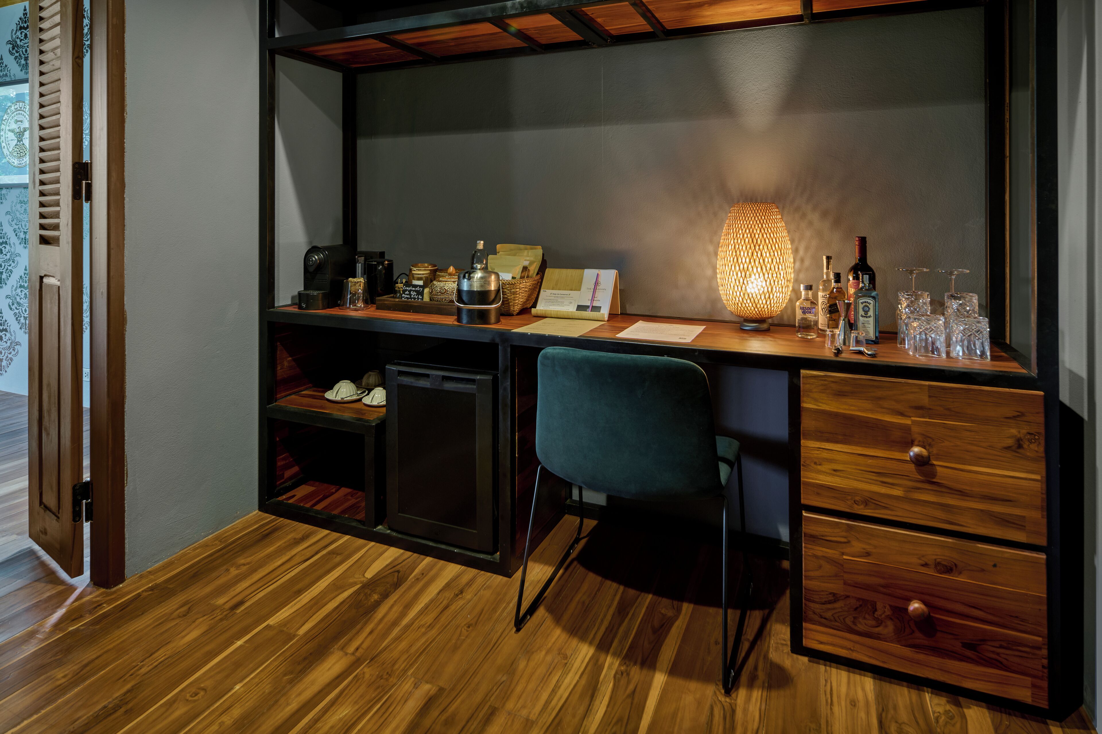 A modern workspace with a wooden desk, a comfortable chair, and a small shelving unit.