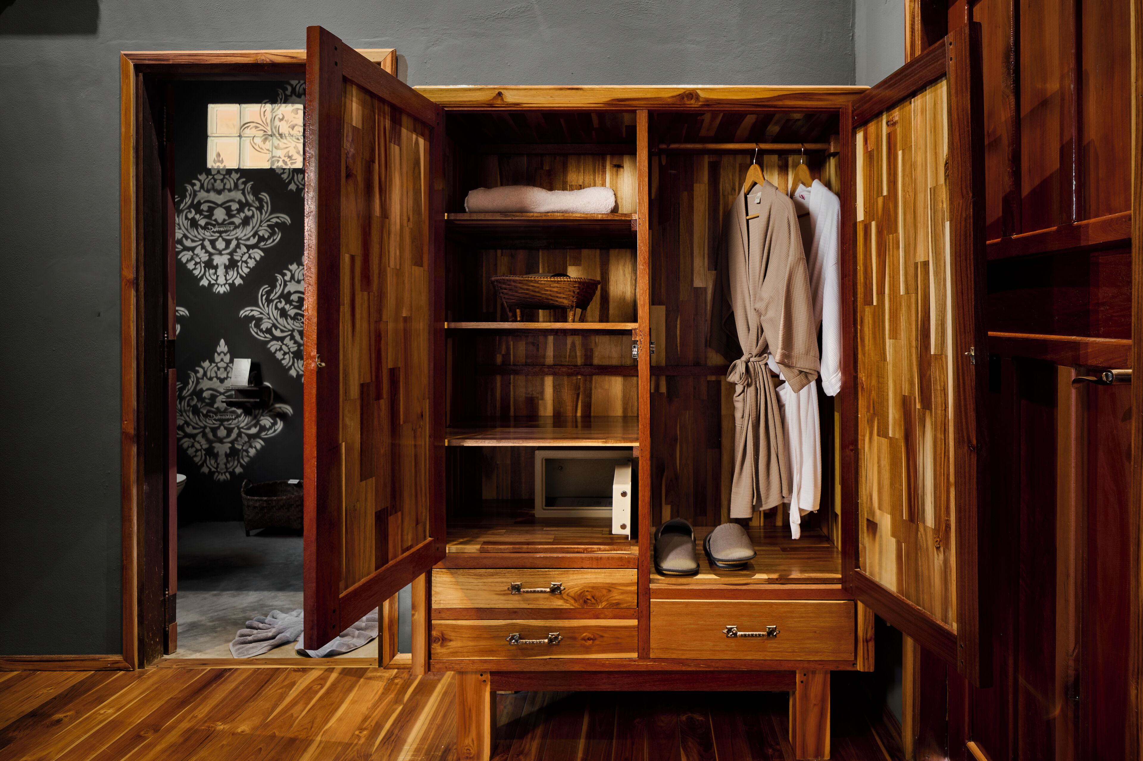 Un armario de madera con puertas abiertas, mostrando estantes, espacio para colgar y cajones.