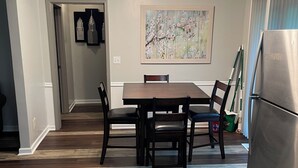 A dining area with a wooden table and chairs, a ceiling fan, and a refrigerator. - RElax, & BeComfortable (Snellville)