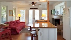 A cozy living room with a red sofa, a wooden coffee table, and a ceiling fan.