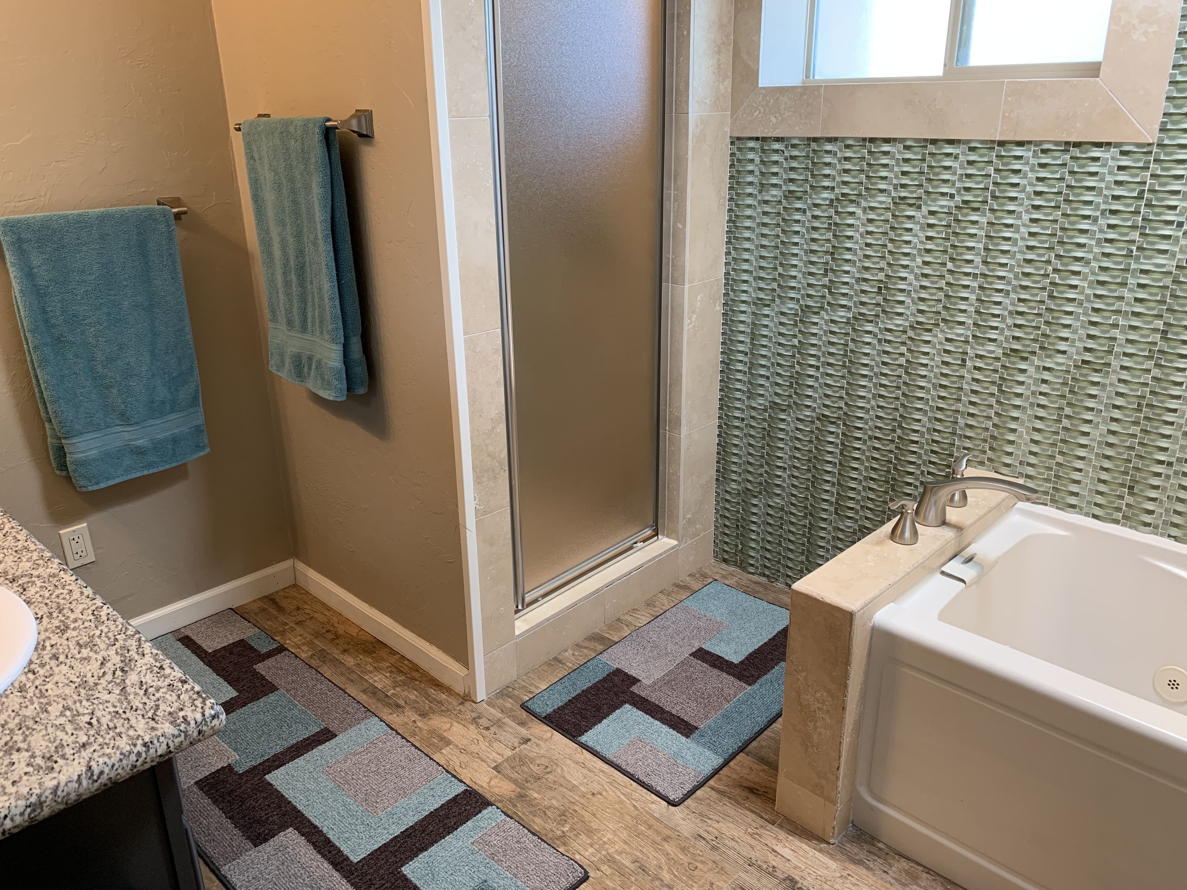 A bathroom with a shower, a sink, and a bathtub.