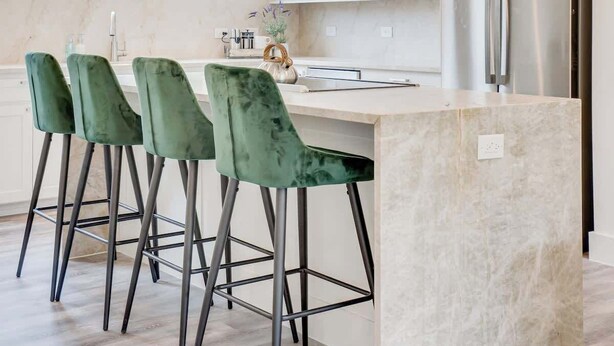 A modern kitchen with a central island, bar stools, a stainless steel refrigerator, and pendant lighting. - Funky | Whimsical |Steps from Highland Park (Dallas)