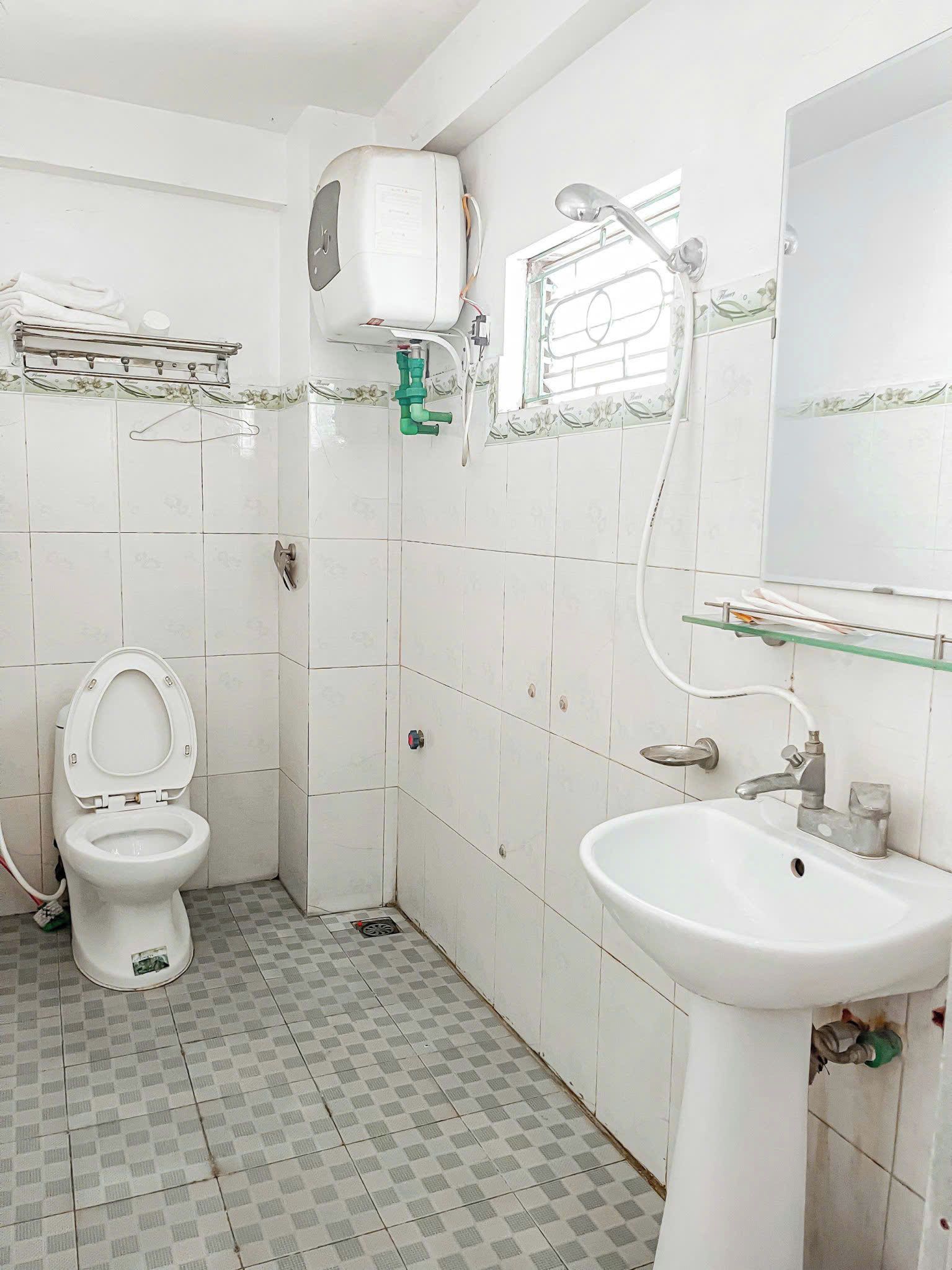 A bathroom with a toilet, sink, and a shower area.