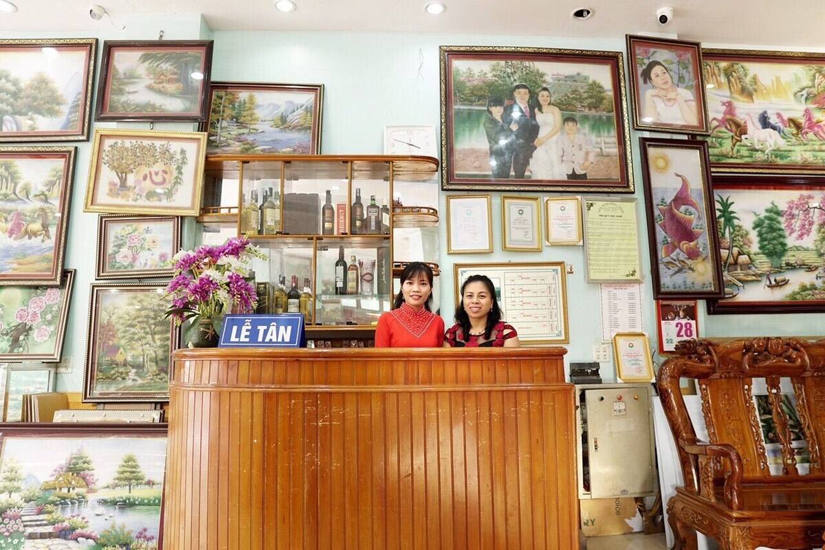 A reception desk with framed artwork on the walls and a sign indicating the location.