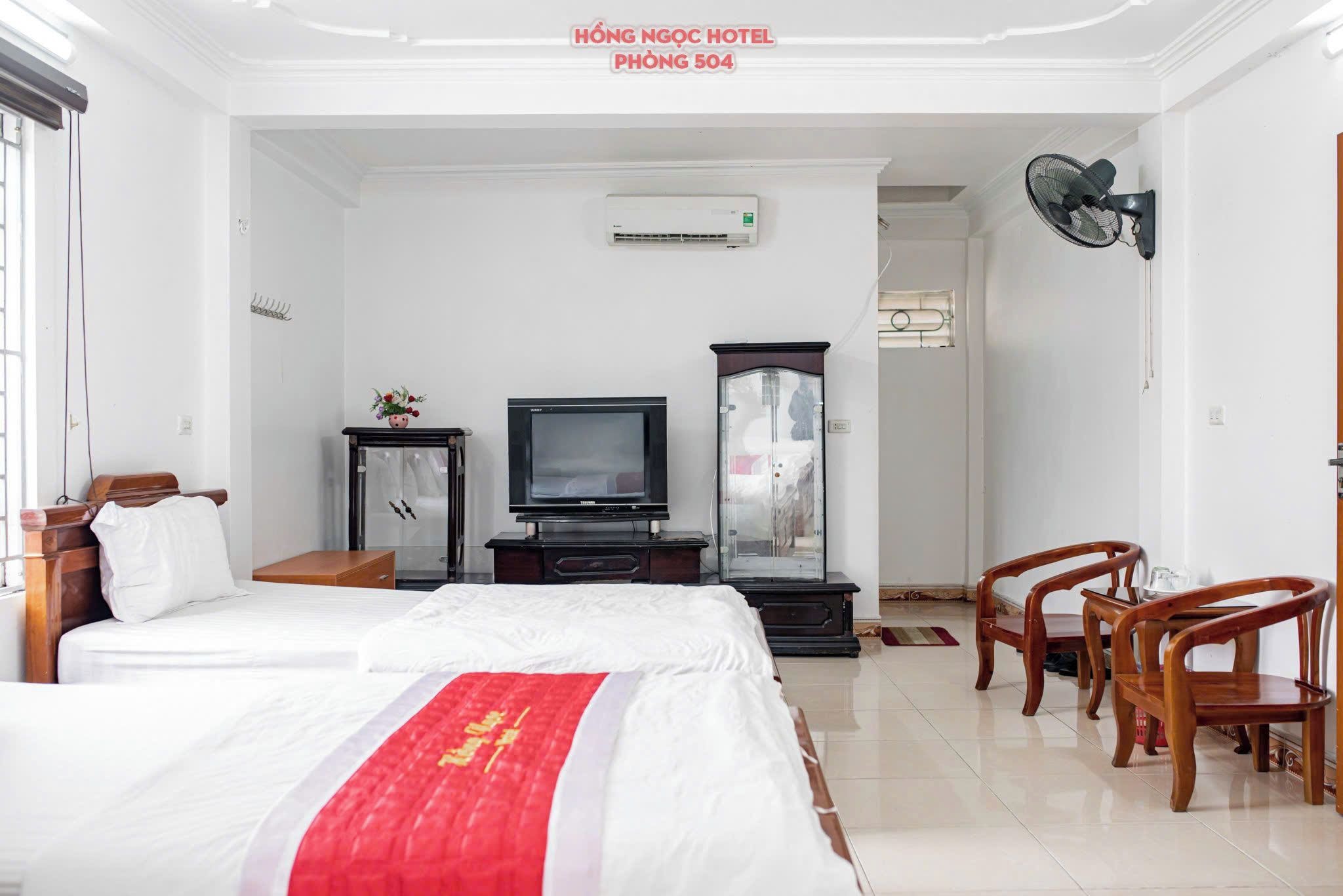 A hotel room with a bed, a television, a cabinet, and a desk.