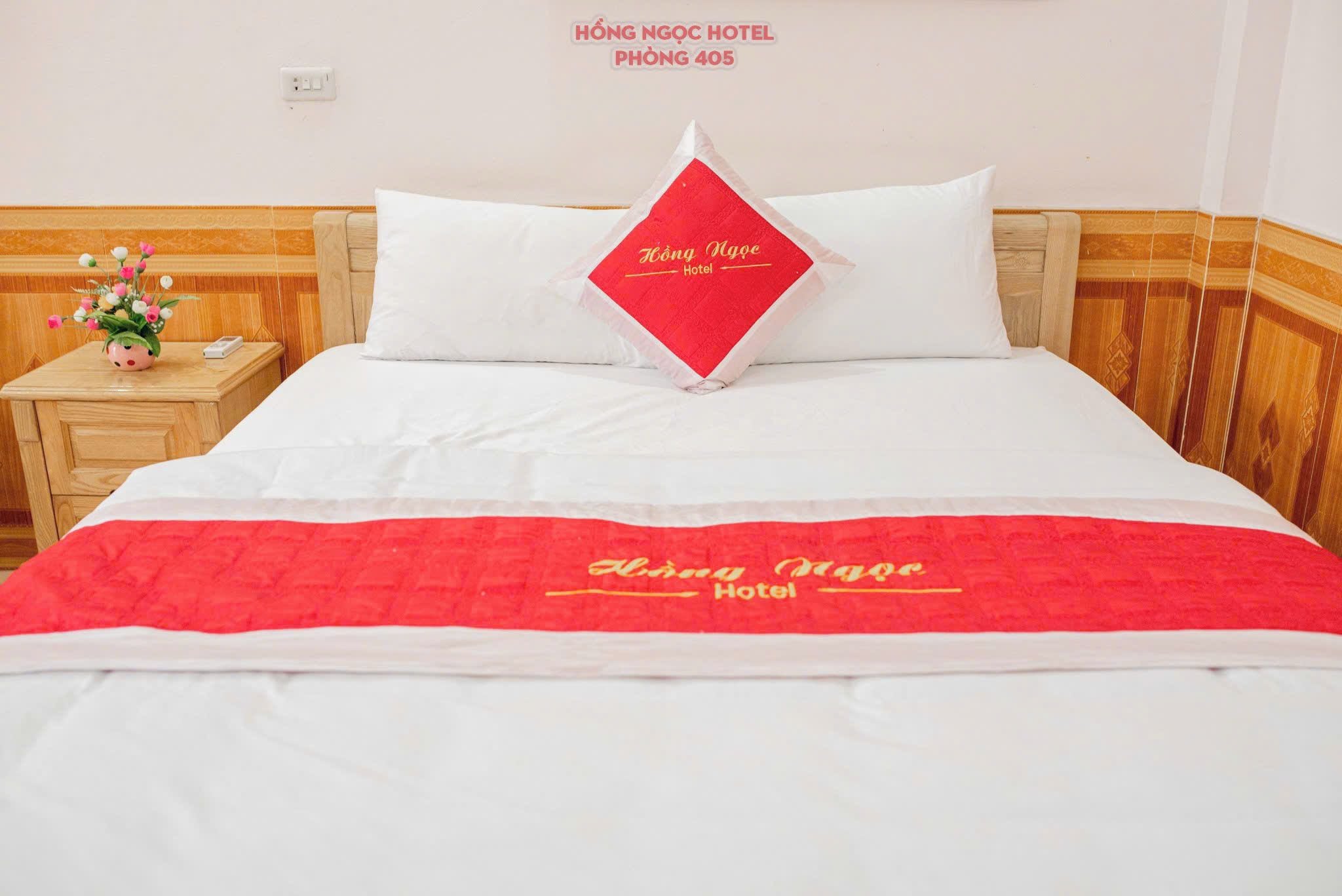 Ein Hotelzimmer mit einem Bett, einem Nachttisch und einem an der Wand befestigten Schild.