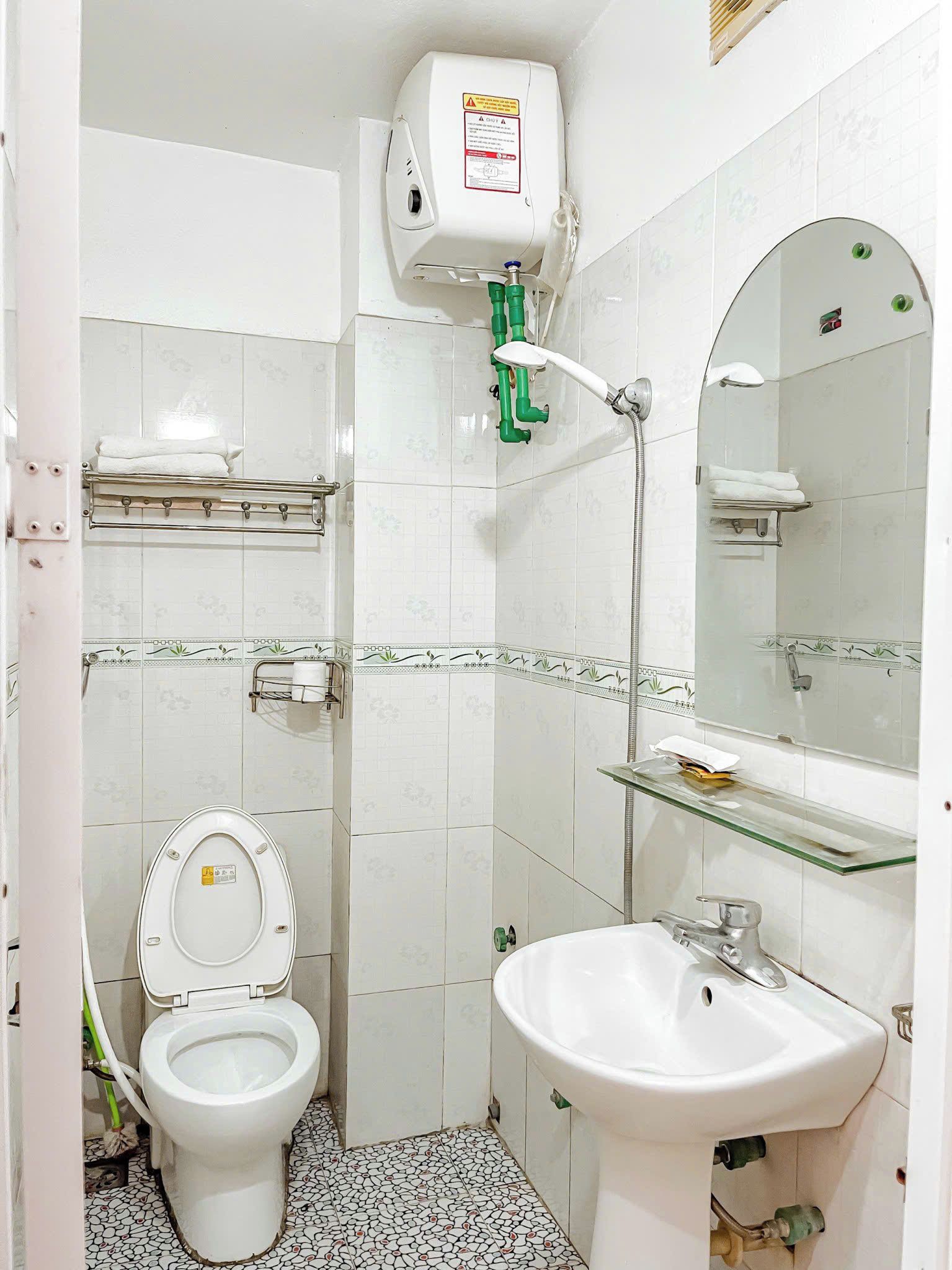 A bathroom with a toilet, sink, and shower.