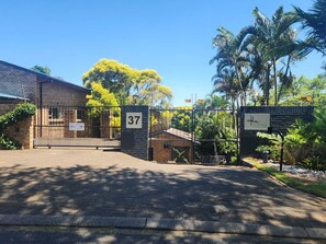 A gated entrance to a building with a brick facade, a sign with the number 37, and a sign indicating 'Hillcrest Manor' with a 'Super Inn' logo. - Hillton Manor Guest House (Richards Bay)