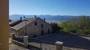 A stone building with a parking lot and a mountain view. - O'Friendly Gold Cottage 14 (Dorres)