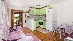 Un espacio habitable compacto con kitchenette, comedor y sofá.
