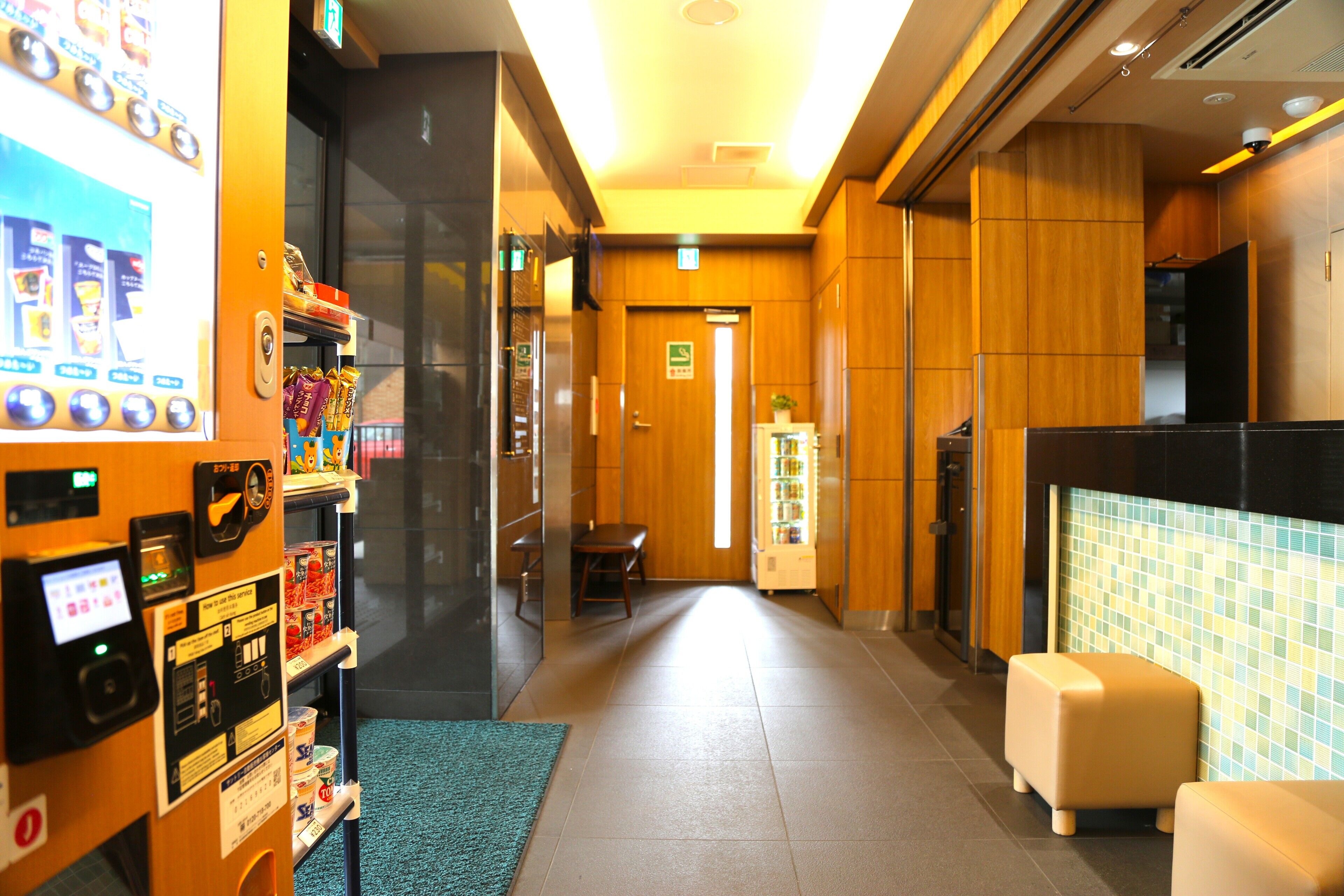 A hotel lobby with vending machines, a reception desk, and a seating area.