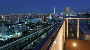 A high-rise building with a view of a cityscape, including a prominent tower and a busy highway. - TOKYO CITY VIEW HOTEL TABATA-STATION (Tokyo)