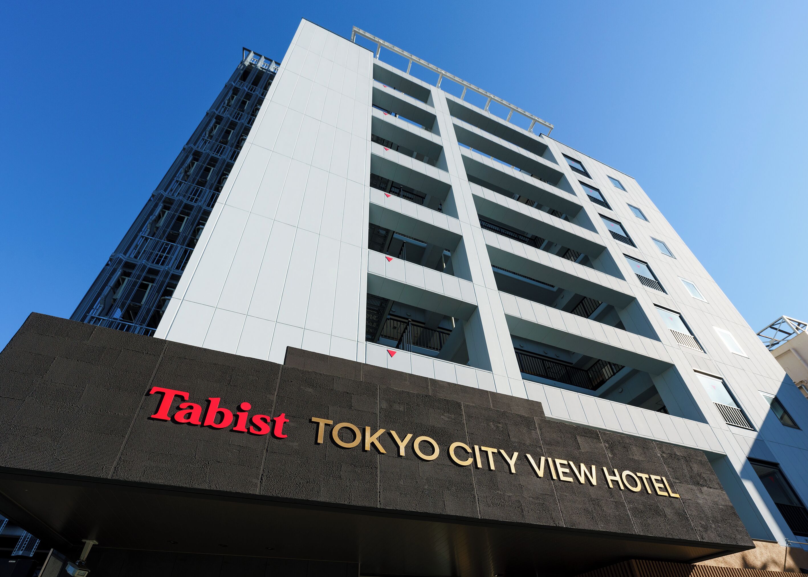 The exterior of the Tabist Tokyo City View Hotel, featuring a modern design with multiple floors and large windows.