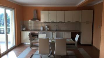 Lavavajillas, cafetera o tetera, utensilios de cocina y mesa de comedor