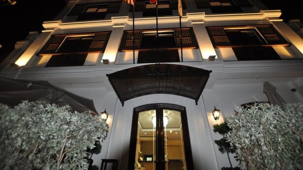 A building with a grand entrance, large windows, and a flag.