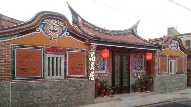 A traditional building with ornate roof tiles, a brick facade, and red lanterns. - Teapot House (Jinning)