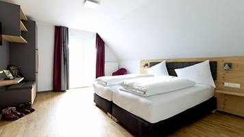 Une chambre avec un lit de style industriel, une commode en bois et un bureau avec une chaise.