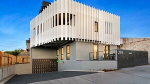 En modern byggnad med en unik arkitektonisk design, som kännetecknas av en kombination av vertikala och horisontella linjer, stora fönster och ett platt tak.