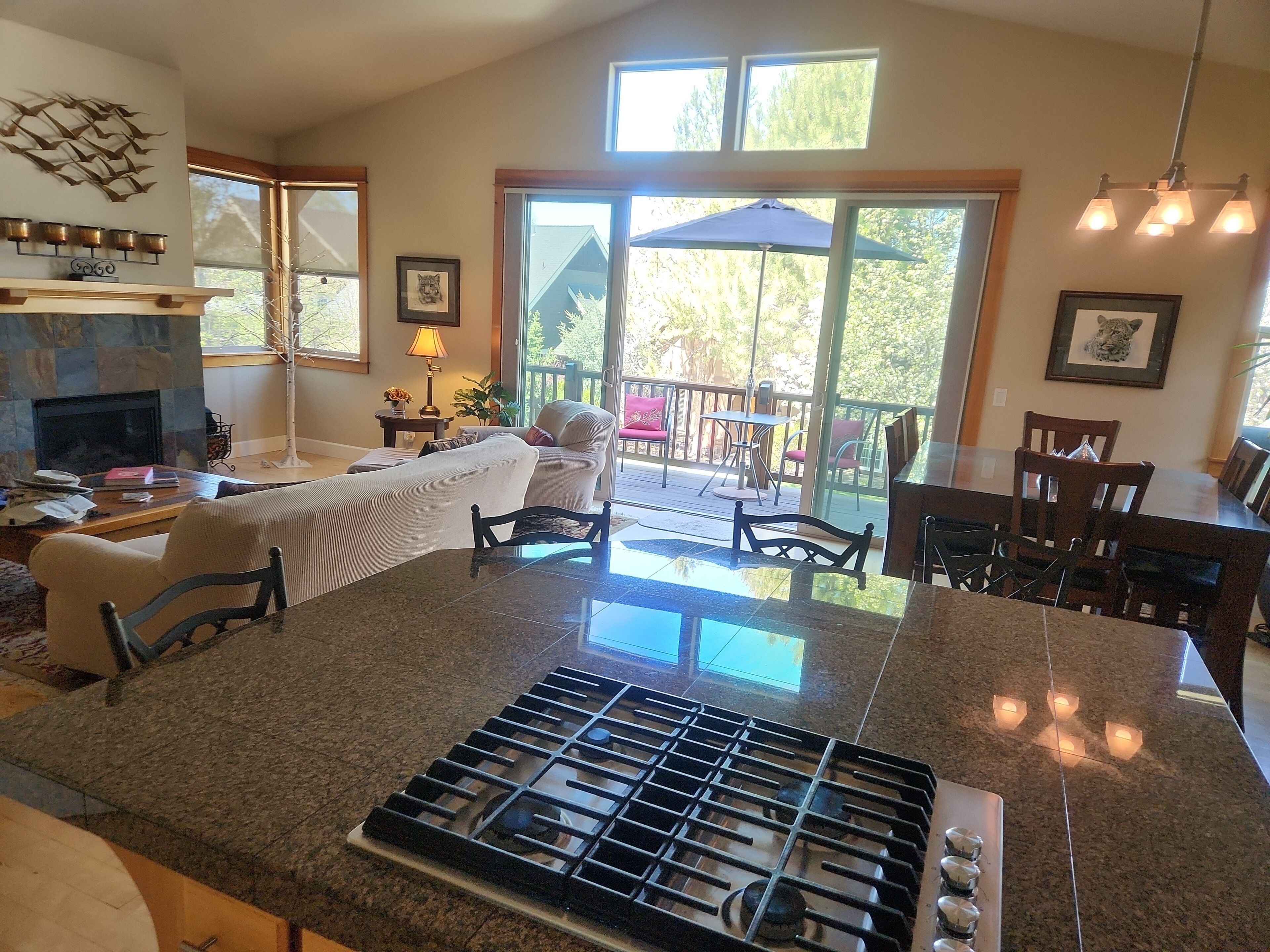 A kitchen with a central island, a dining area with a table and chairs, and a fireplace.