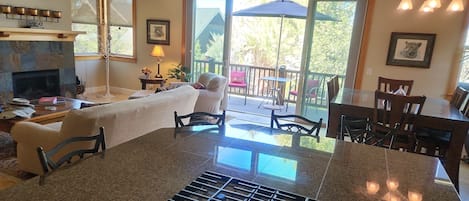 A kitchen with a central island, a dining area with a table and chairs, and a fireplace.