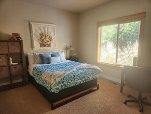 Enjoy a restful stay in this cozy room with a neatly made bed, wooden nightstand, and desk area.