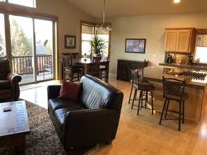 Relax in this inviting living space with a sofa, armchair, and dining area offering a view of the outdoors.