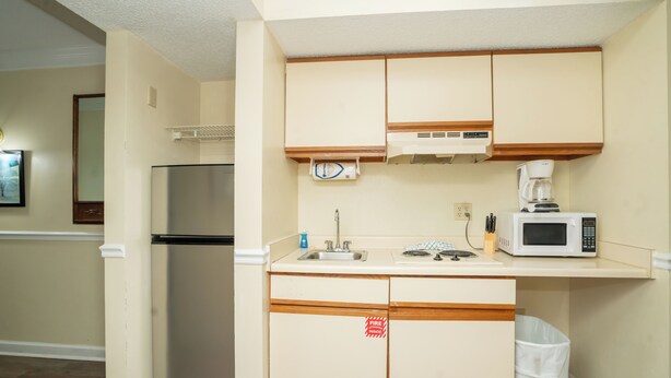 Cocina pequeña con refrigerador, microondas y estufa.