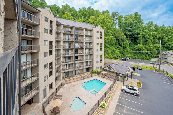 A multi-story hotel with a swimming pool and outdoor seating area.