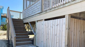 A wooden deck with a staircase leading to a covered area.