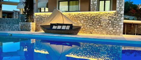 Een buitenzwembad, parasols voor strand/zwembad